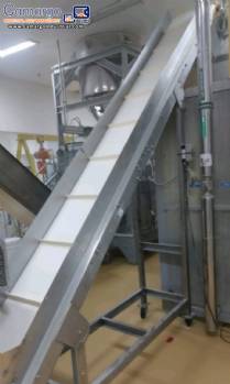 Inclined conveyor belt with stainless steel cleats.