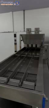 Automatic stainless steel deep fryer for donuts and cream puffs.